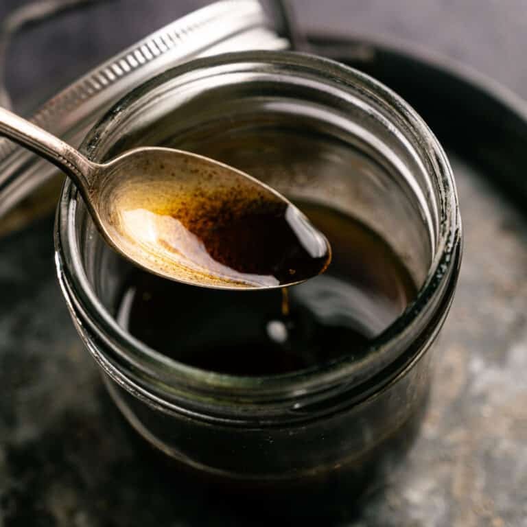 Balsamic maple vinaigrette being spooned into a glass jar.