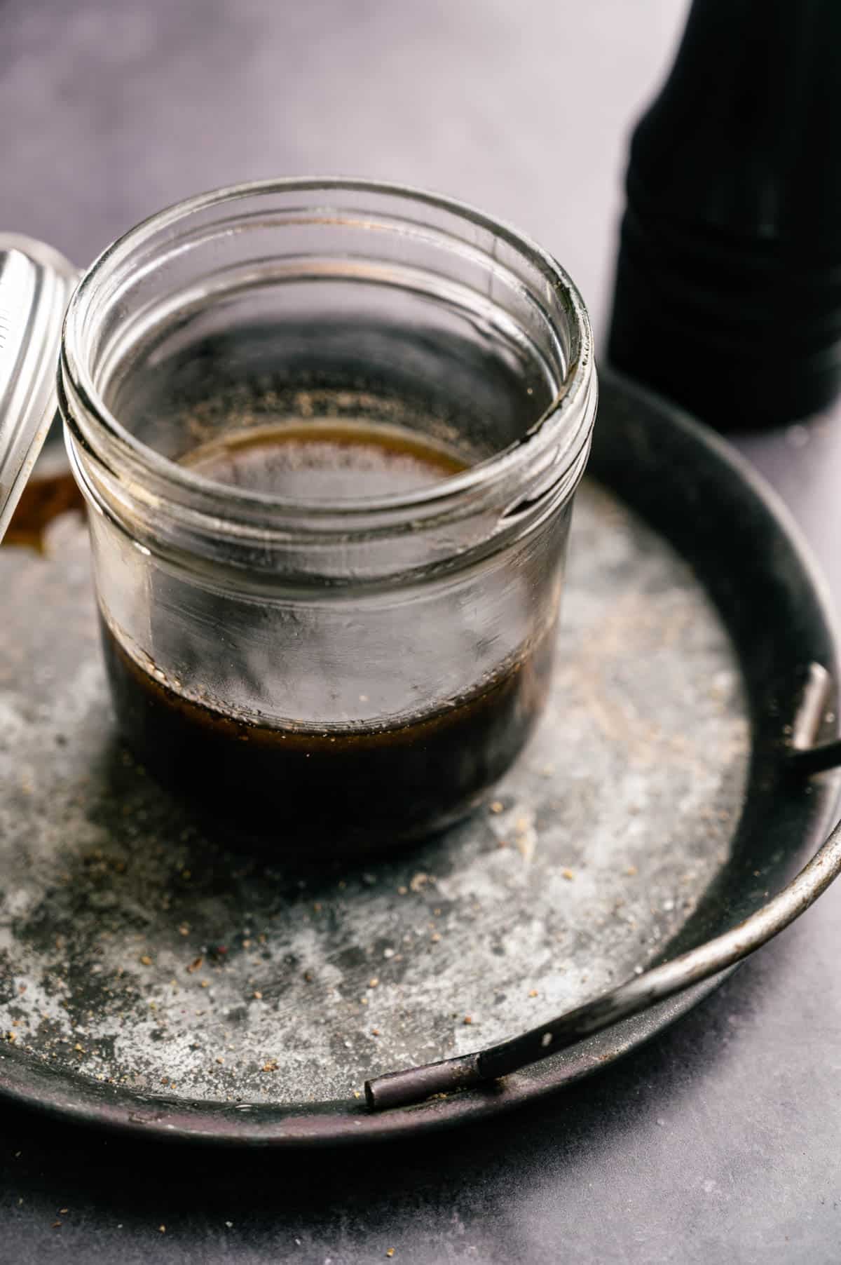 Maple syrup and balsamic vinaigrette in a glass jar.