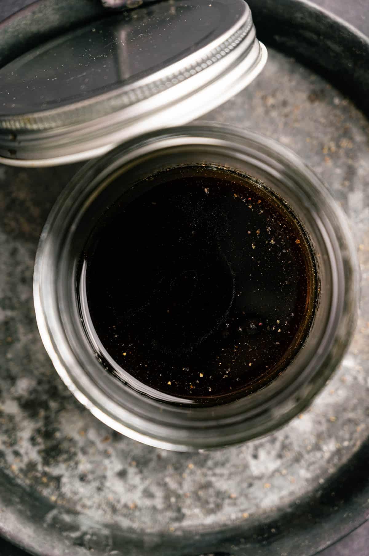 Maple syrup and balsamic vinaigrette in a glass jar.
