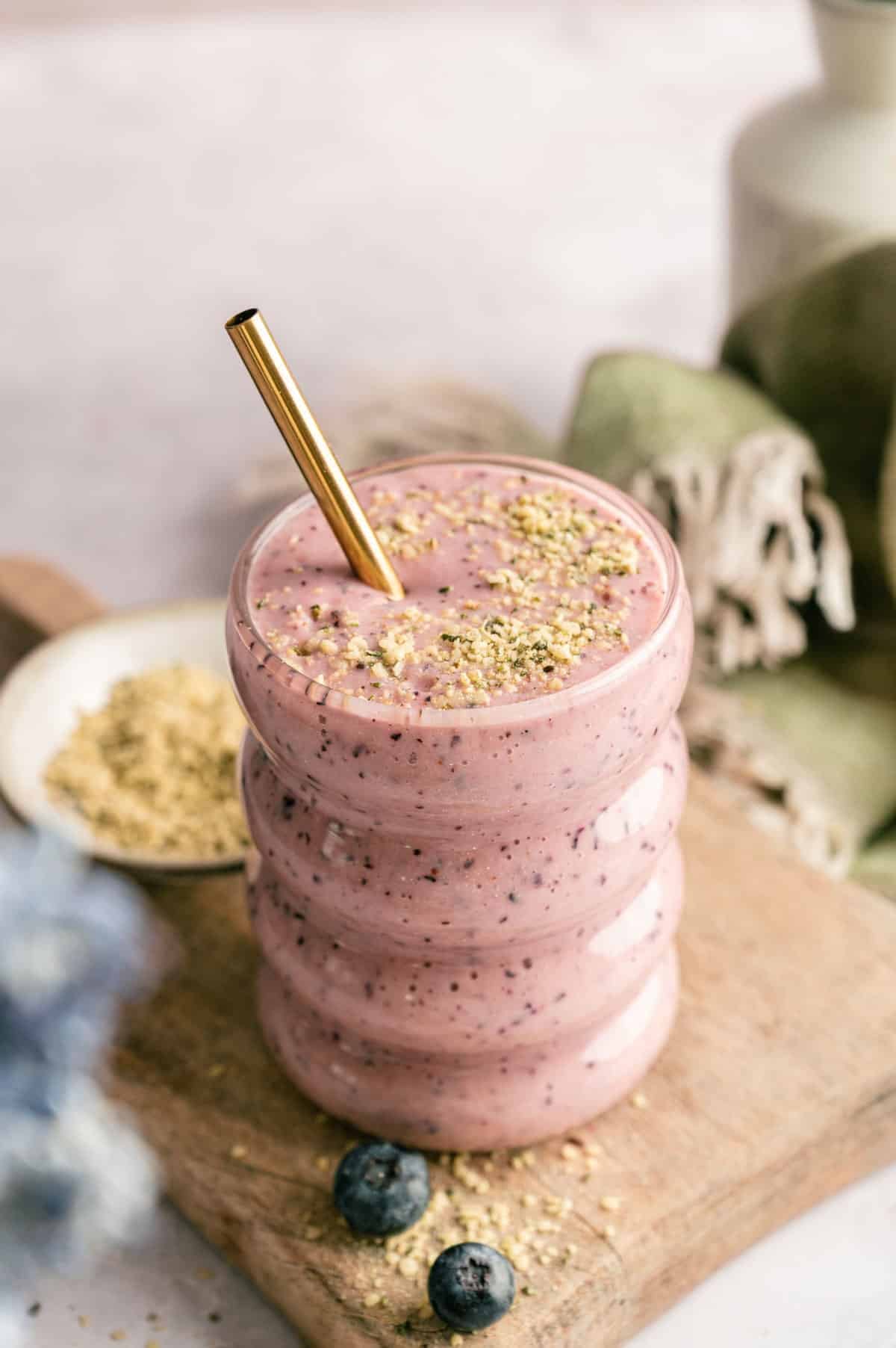 Metal straw in a cup of homemade pineapple and blueberry smoothie.